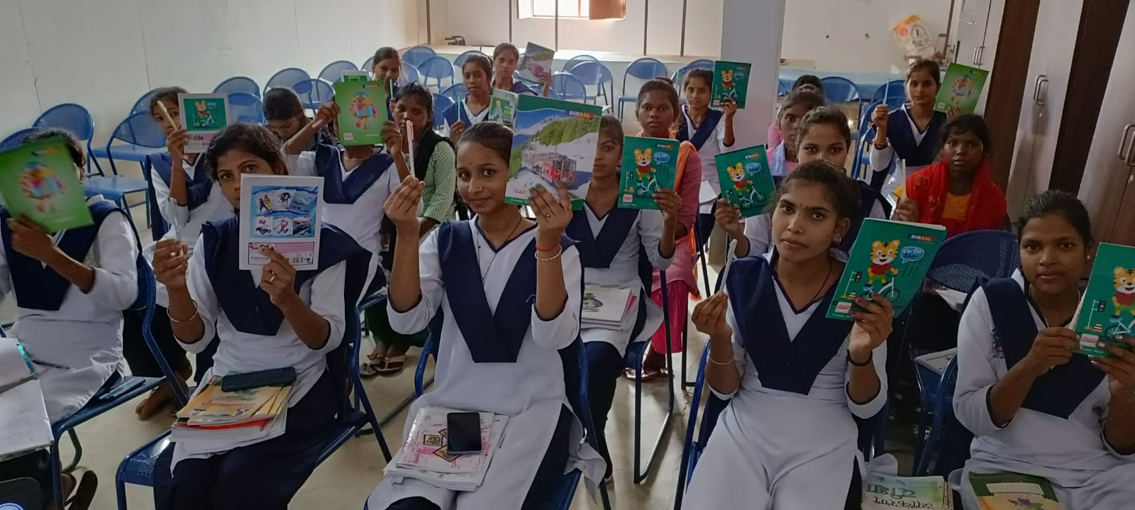Young women at a training centre holding their new notebooks and stationery