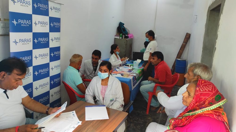 A woman being attended to by a doctor at a health camp